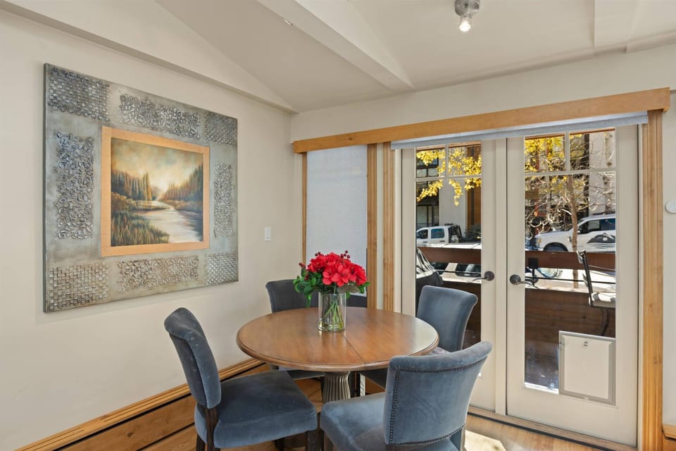 The dining table is nestled into the corner with beautiful French doors.