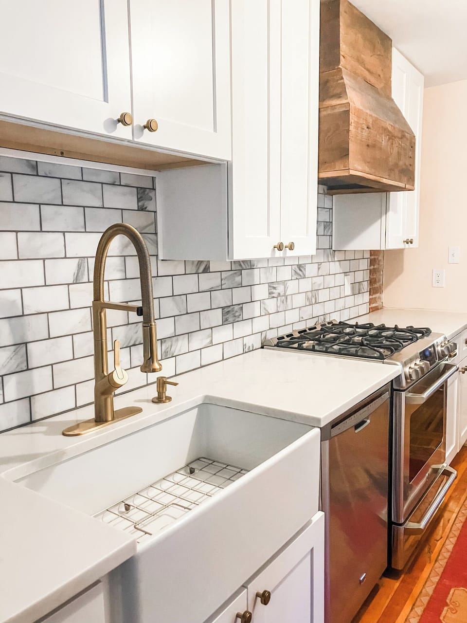 Kitchen with gas range, farm sink, quartz counters, stainless steel appliances