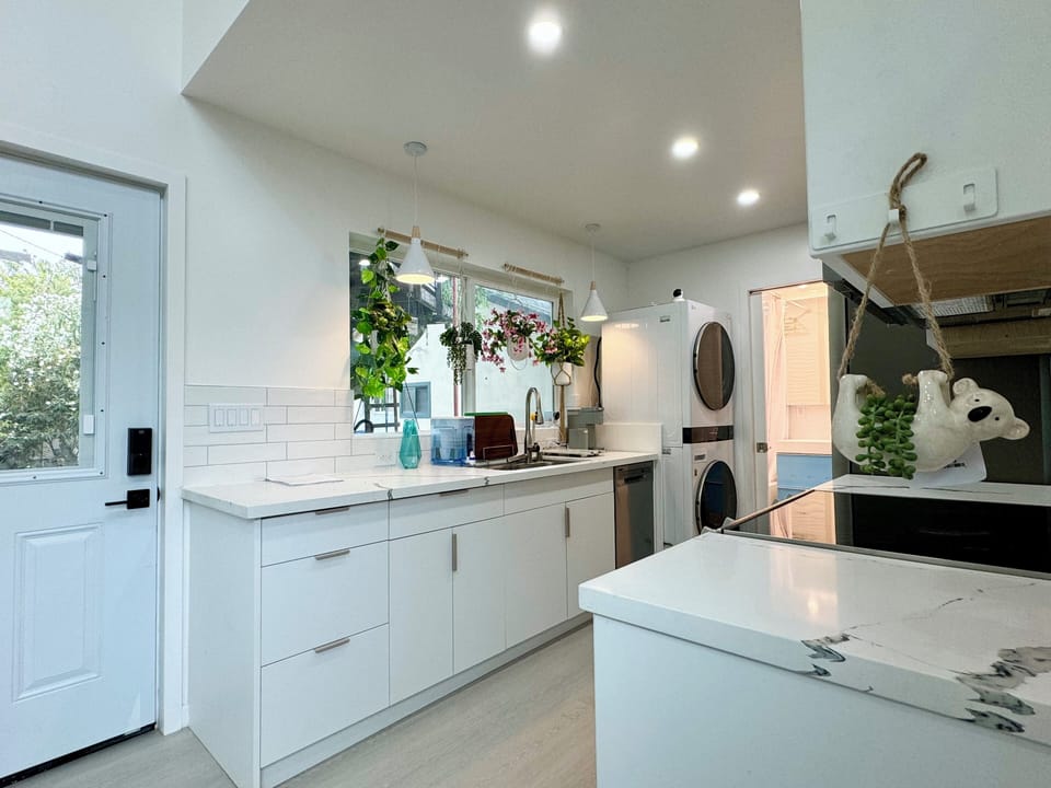 Bright kitchen with modern appliances, laundry, and stylish decor.