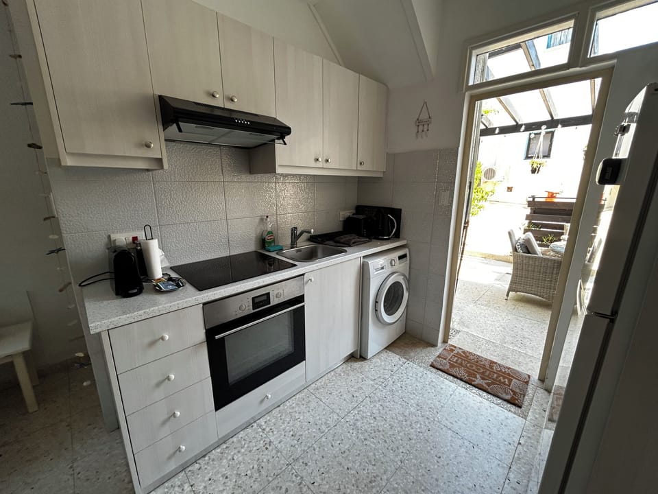 Modern kitchen with all essentials, leading to a courtyard for al fresco dining