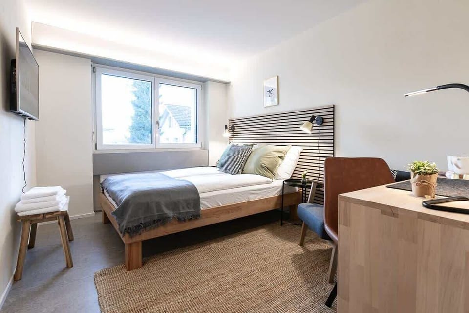 Das Zimmer verfügt über ein 140/200 Bett mit Federkern Matratze und eine Dusche/WC. Die geteilte vollausgestattete Küche ist am Ende des Ganges auch mit dem Zimmerschlüssel zugänglich