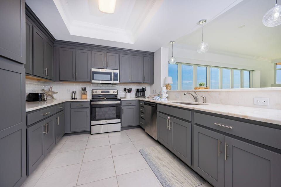 Prepare meals in this stylish kitchen under glass pendant lighting with stainless appliances and elegant cabinetry