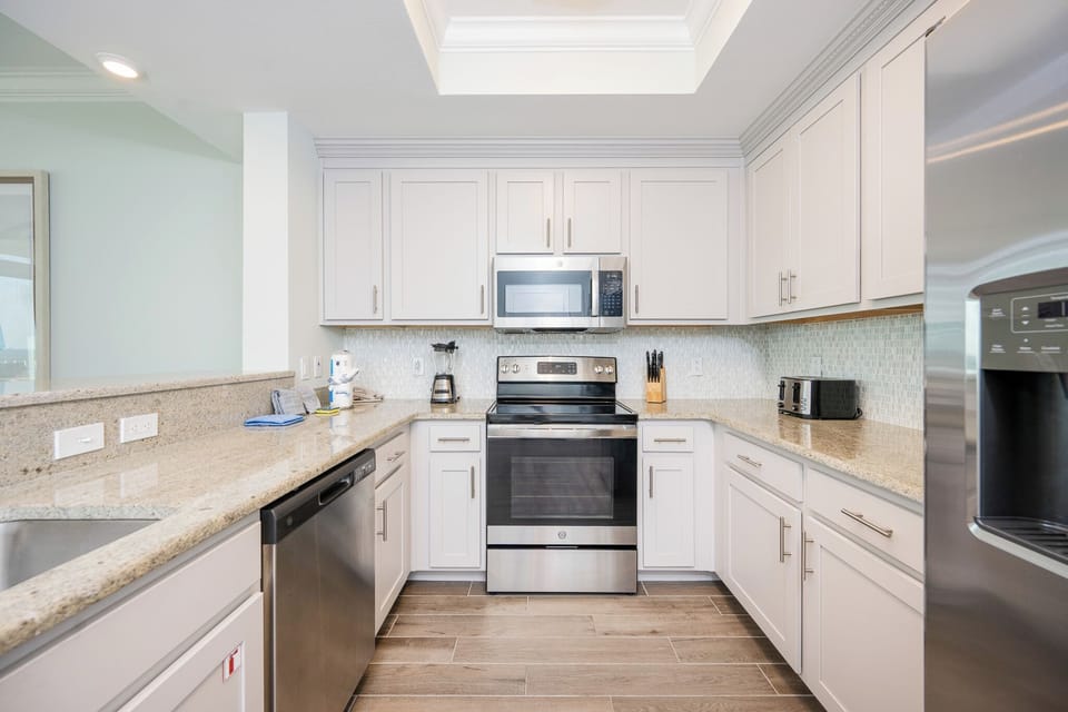 Prepare meals in this kitchen with elegant cabinetry, stainless appliances, and spacious countertops
