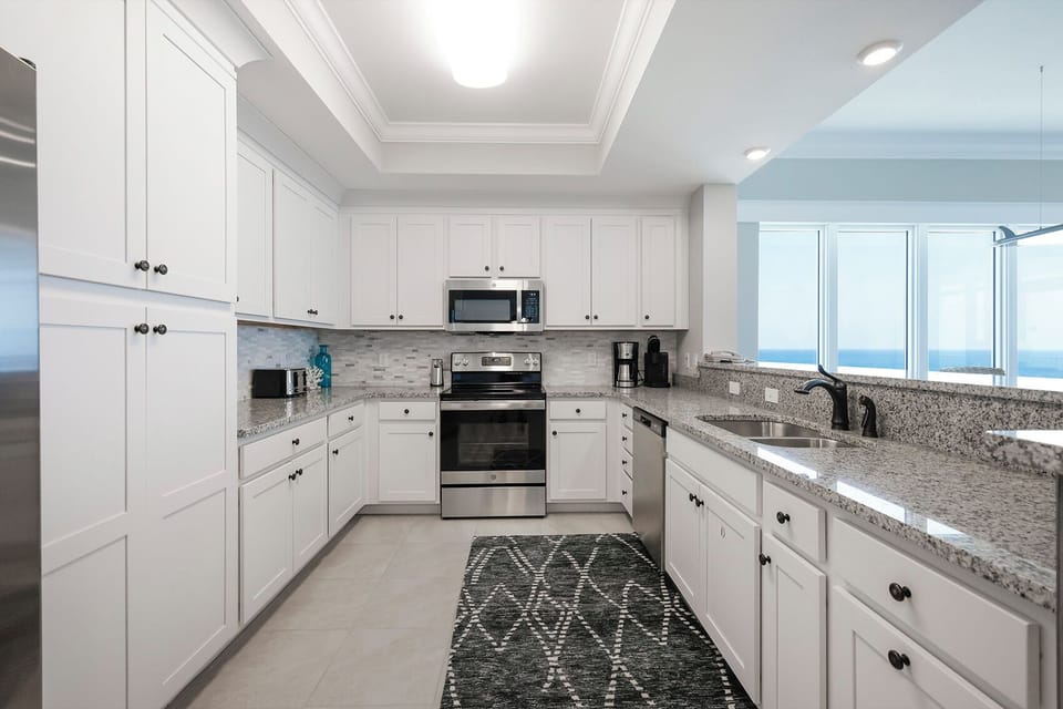 Prepare meals in this kitchen with elegant cabinetry, stainless appliances, and spacious countertops
