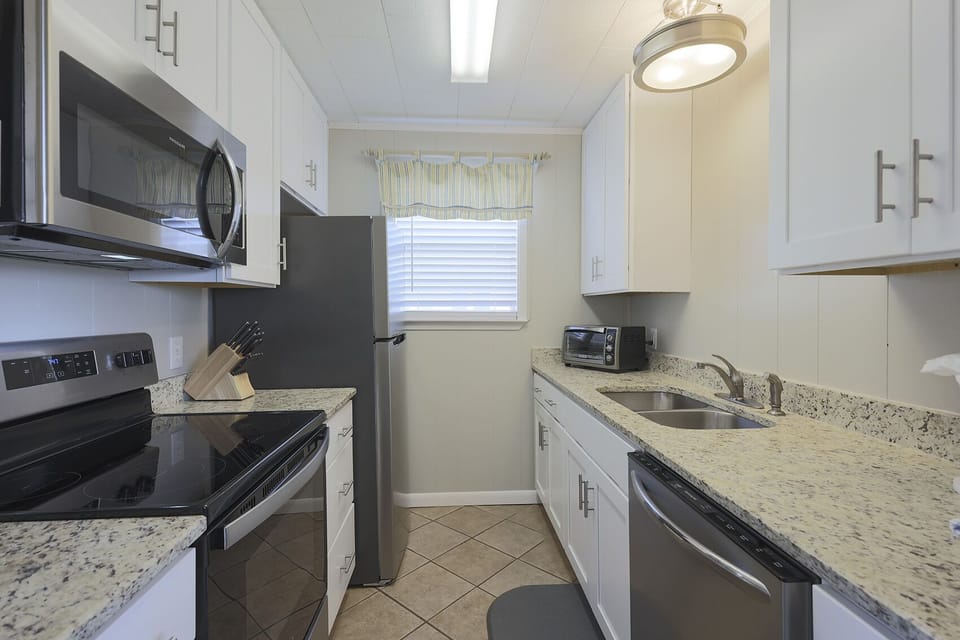 This kitchen features stainless appliances, granite countertops, and a cozy atmosphere perfect for meal preparation