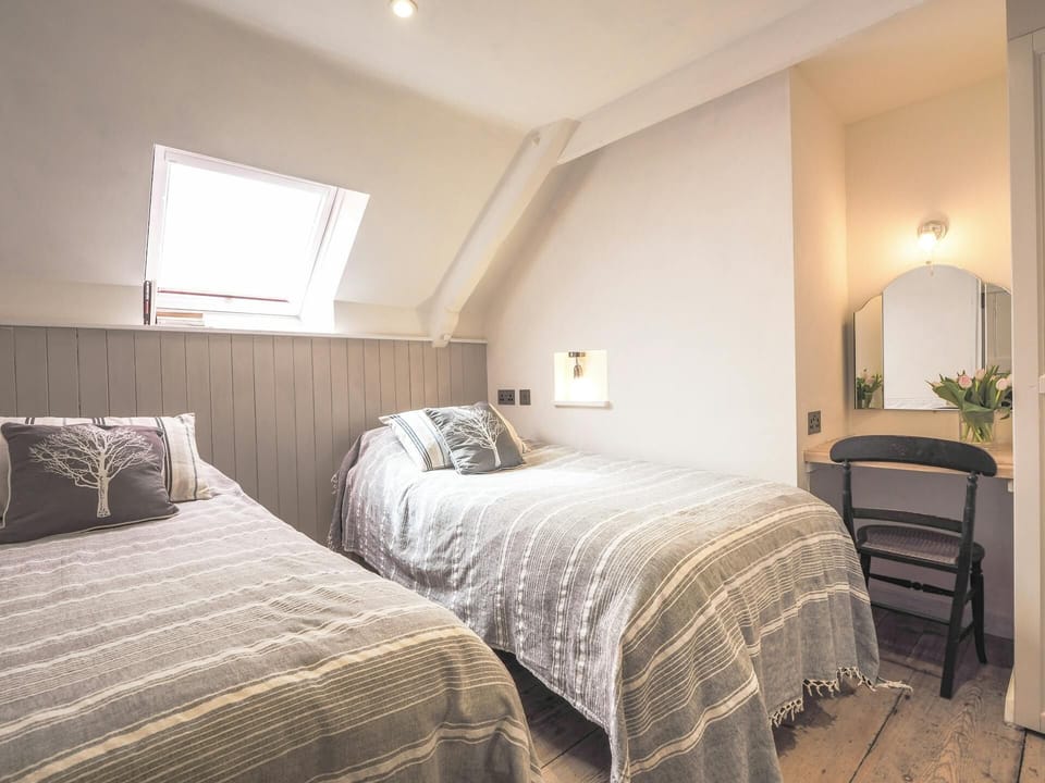 Twin bedroom with a single bed, double bed and vanity desk