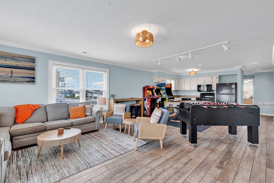 The game room with air hockey, foosball, arcade games, seating, and Roku TV 