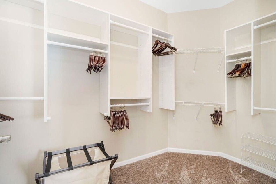 Walk-in closet, hangers, luggage rack, iron, ironing board.