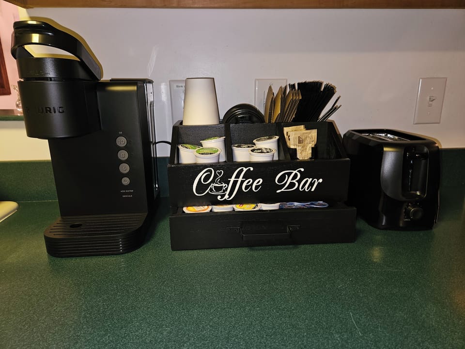 Coffee bar features a variety of K-cups, teas, sweeteners, creamers & to-go cups