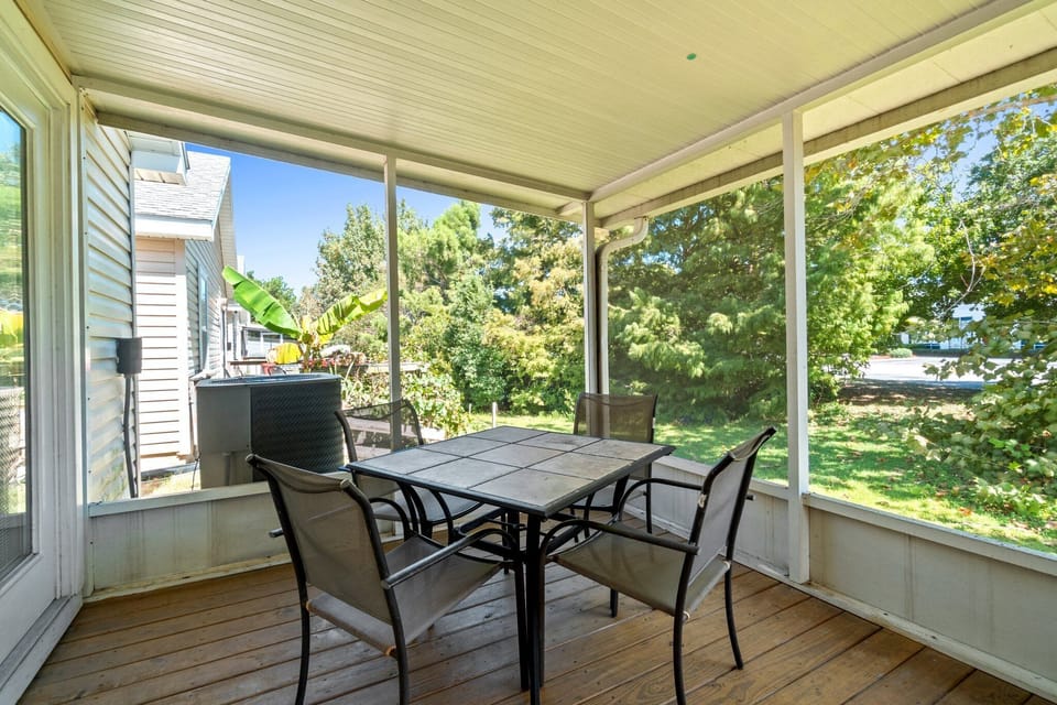 Screened in back patio with a table and 4 chairs