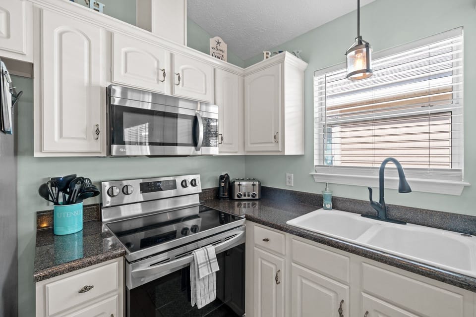 Fully stocked kitchen with microwave, stove, and sink