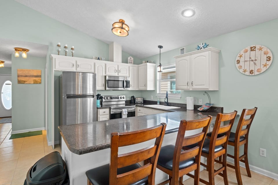 Fully stocked kitchen with 4 barstools at the counter