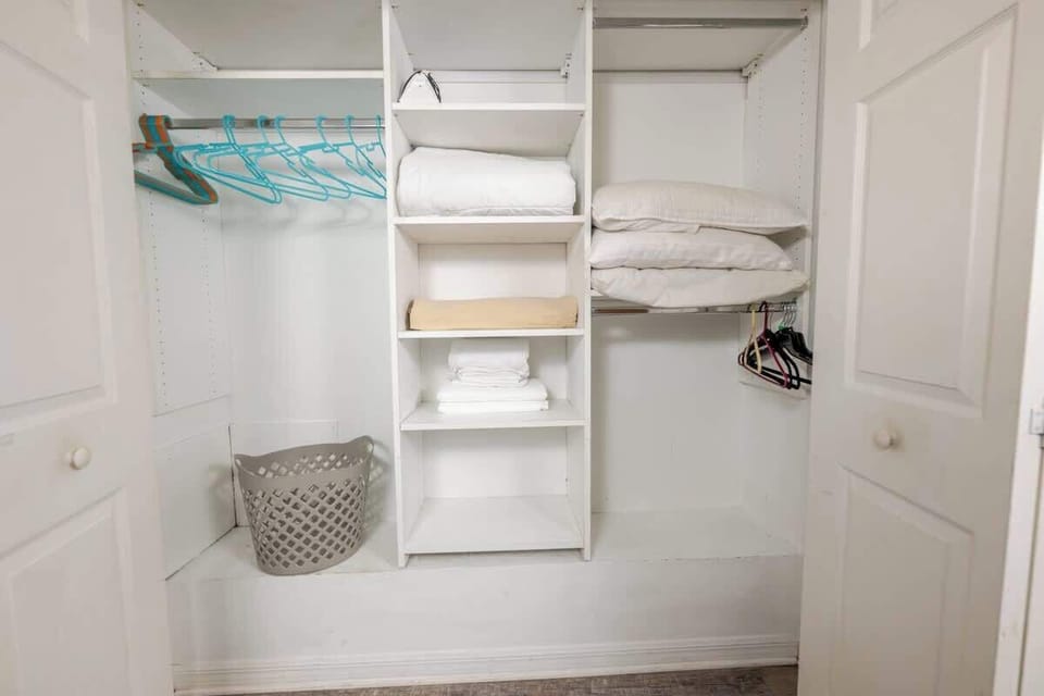 Full closet with built-in shelving, hanging space, and neatly folded linens, ready for storage.