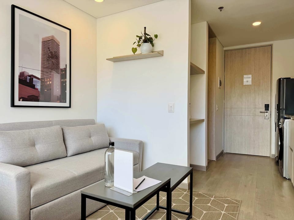 Cozy entrance area with a sofa, coffee table, and wall art.
