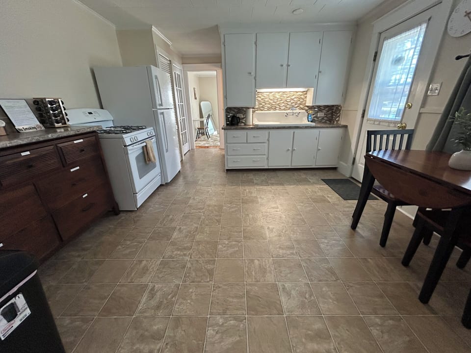 Full kitchen with cooking utensils, pots and pans.