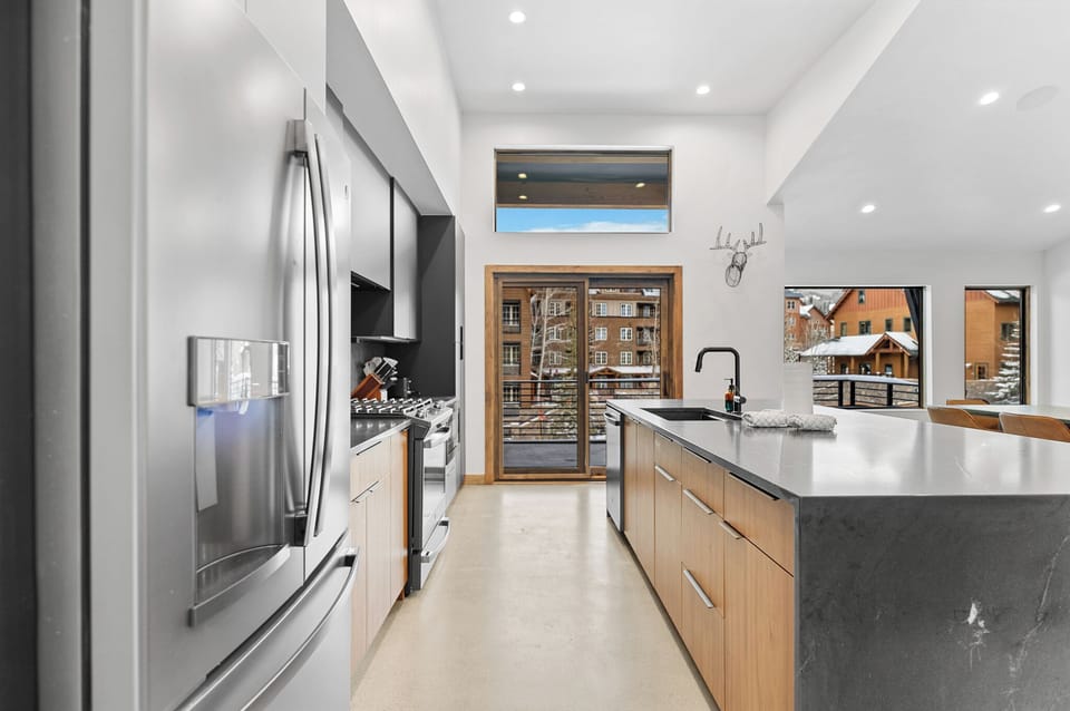 Your sleek modern kitchen features premium appliances and stunning mountain views through expansive windows.