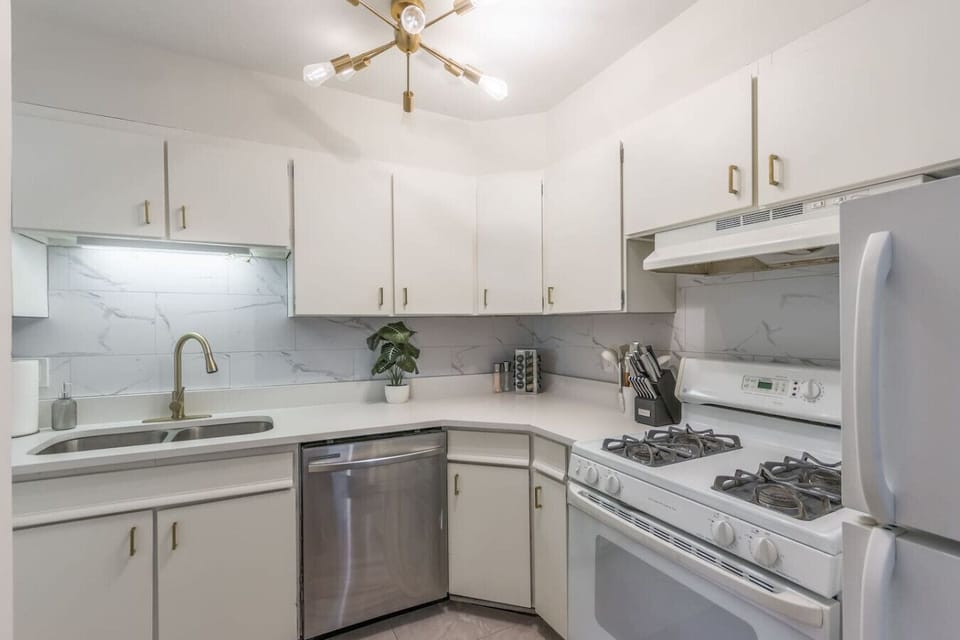 Fully equipped kitchen with crisp white cabinets, updated appliances and stylish gold hardware. Includes dishwasher, gas stove, and full-size fridge…perfect for home cooking or quick meals during your stay.
