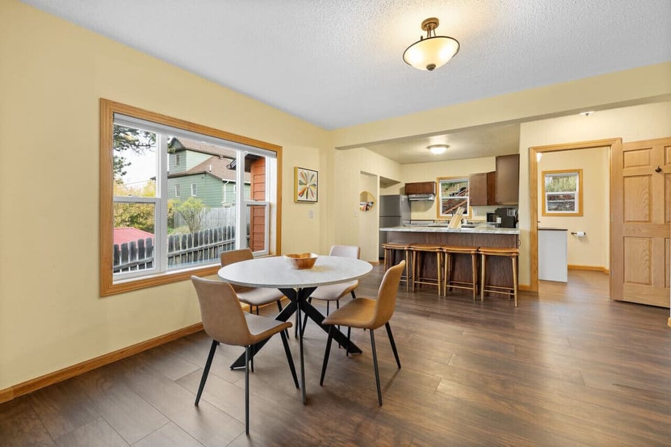 The inviting space includes a dining area with tables and chairs, complemented by a stylish island featuring additional seating, creating an ideal spot for meals and socializing.
