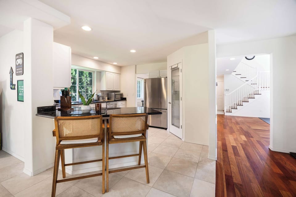 A modern, open kitchen with plenty of natural light and a stylish bar area perfect for casual meals or conversation.