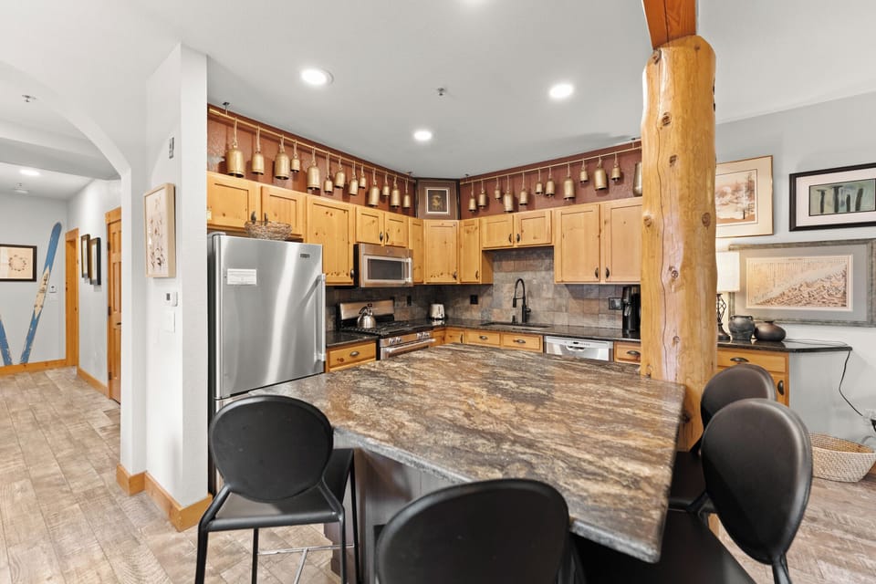 Full kitchen featuring stainless steel appliances, and breakfast bar with seating for 4.