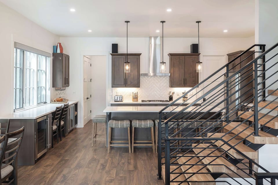 - Modern kitchen with a large island, bar seating, and sleek finishes, perfect for cooking and gathering. Bright, open design makes it a welcoming space for meals and conversation.
