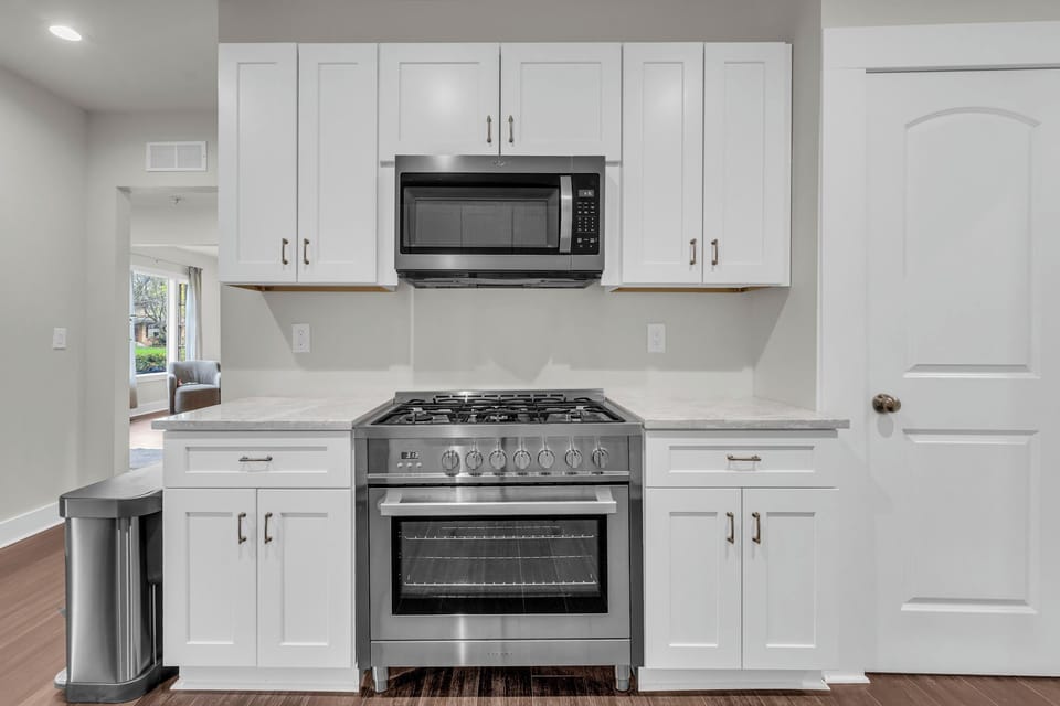 Modern kitchen featuring marble countertops, & stainless appliances
