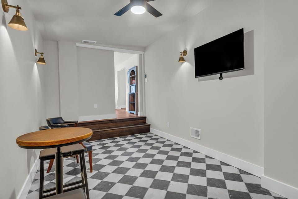 Stylish modern room featuring checkered floors & cozy dining setup