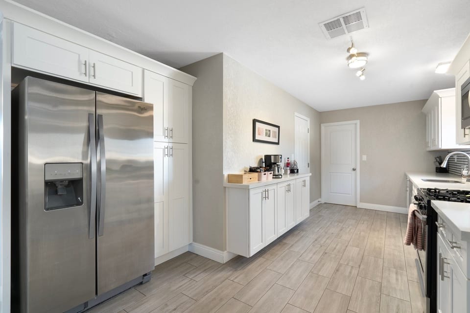 Featuring a large fridge and a stylish coffee bar.