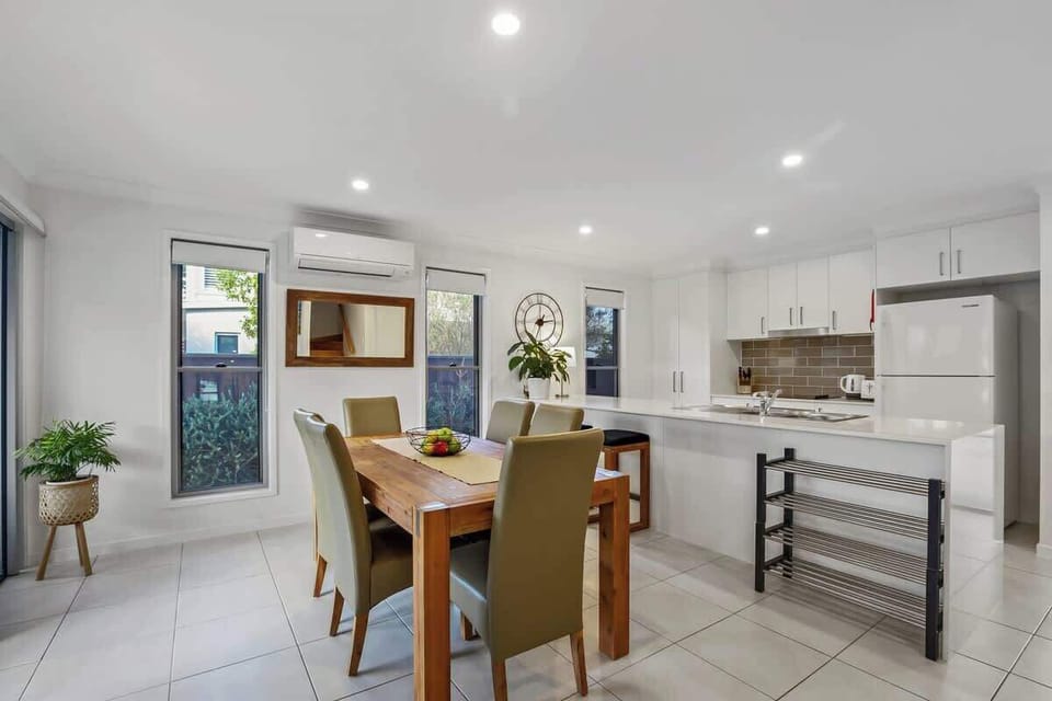 Sit down to shared meals at home at the large six-person dining table. The open plan living area flows straight to the patio.
