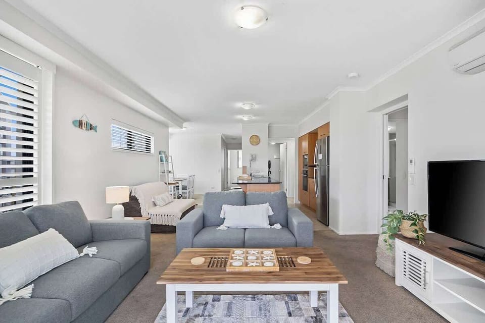 The living room is open plan with plush sofa seating and a central TV for relaxing after a busy day.
