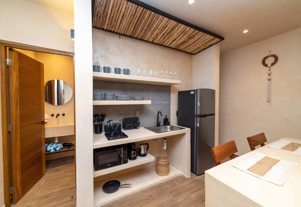 a kitchen with sink and refrigerator in Tulum apartment accommodations