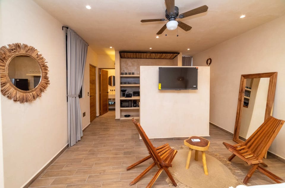 a bedroom with bed and chair in Tulum apartment accommodations