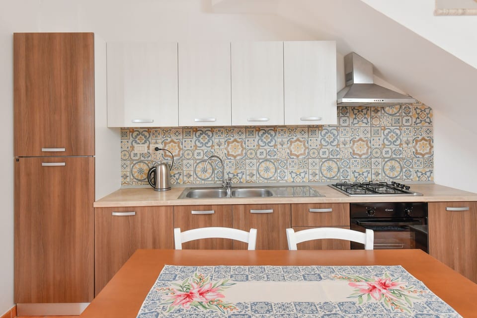 Cozy kitchen with modern fridge, stove, oven, tile accents & dining area.