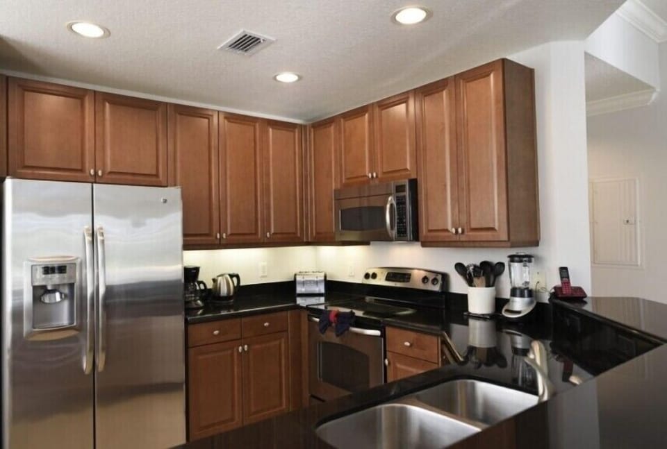 Fully equipped kitchen with rich wooden cabinetry and stainless steel appliances.