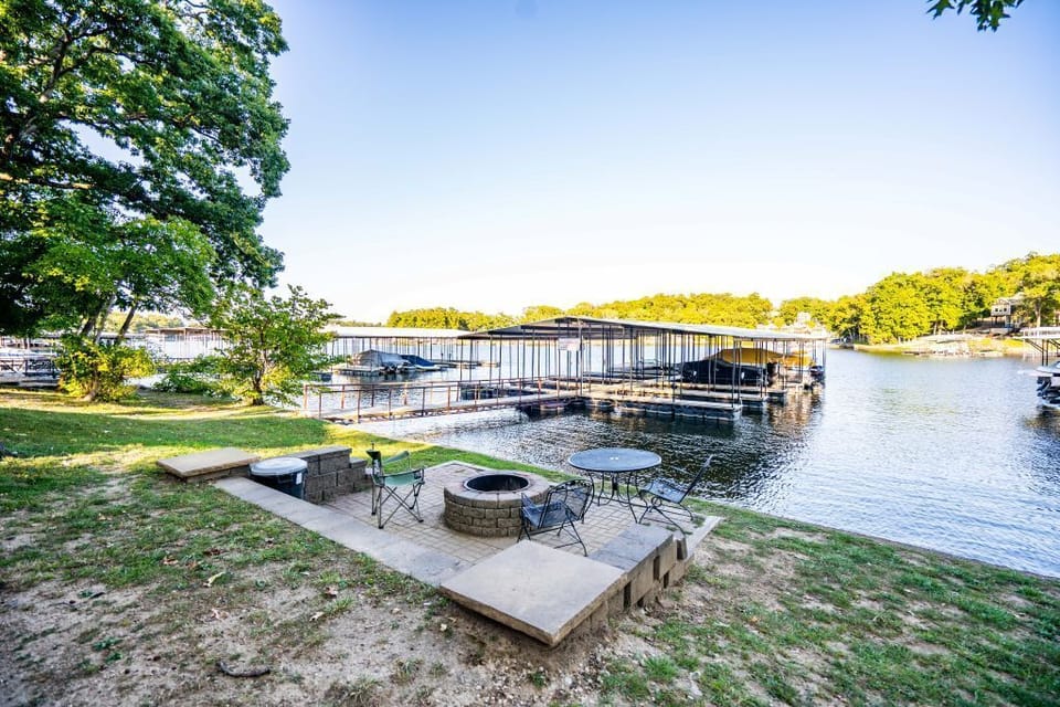 Relax by the lakeside fire pit with peaceful views of the dock and cove.