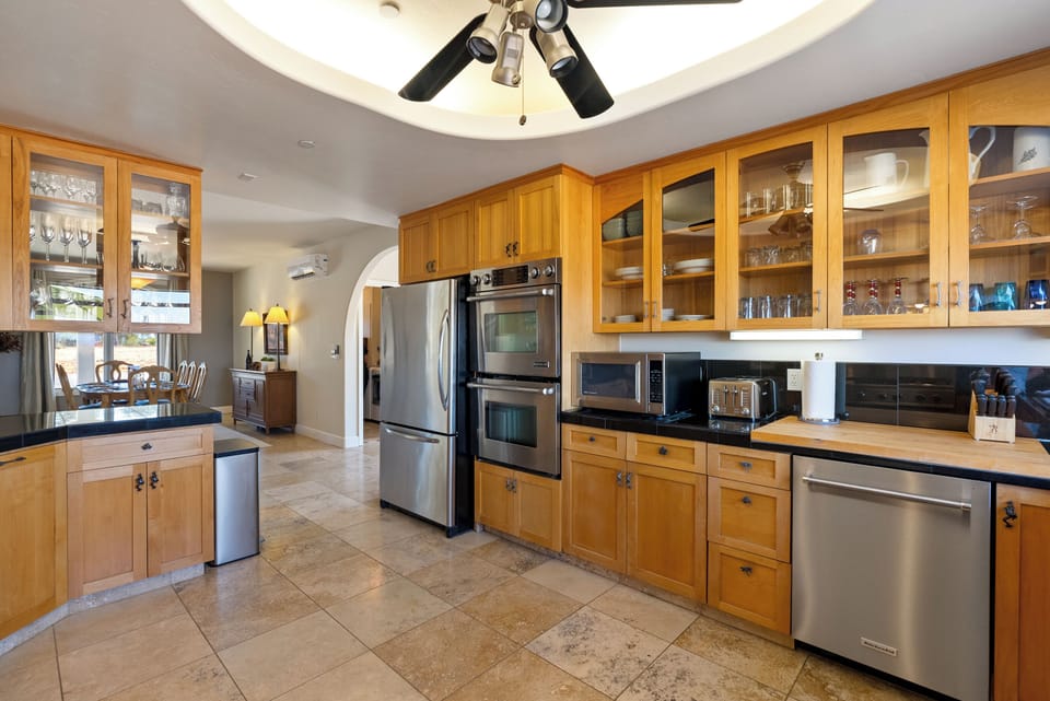 A spacious chef's kitchen, featuring warm wood cabinetry, high-end stainless steel appliances, and ample counter space.