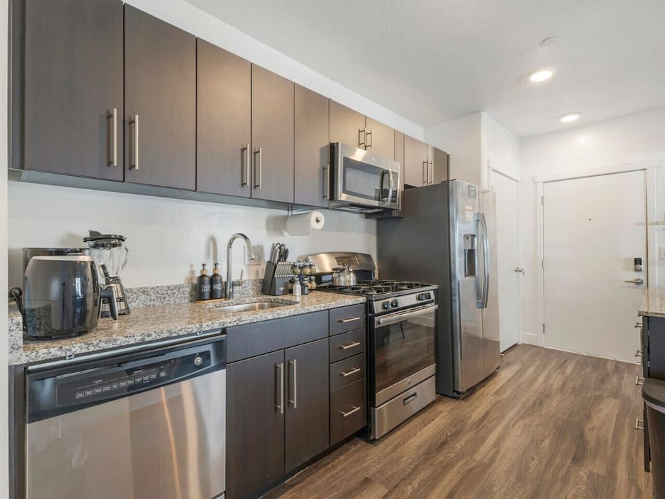 Sleek modern kitchen with stainless steel appliances & granite counters—fully equipped for all your cooking needs! 🍳✨🥂