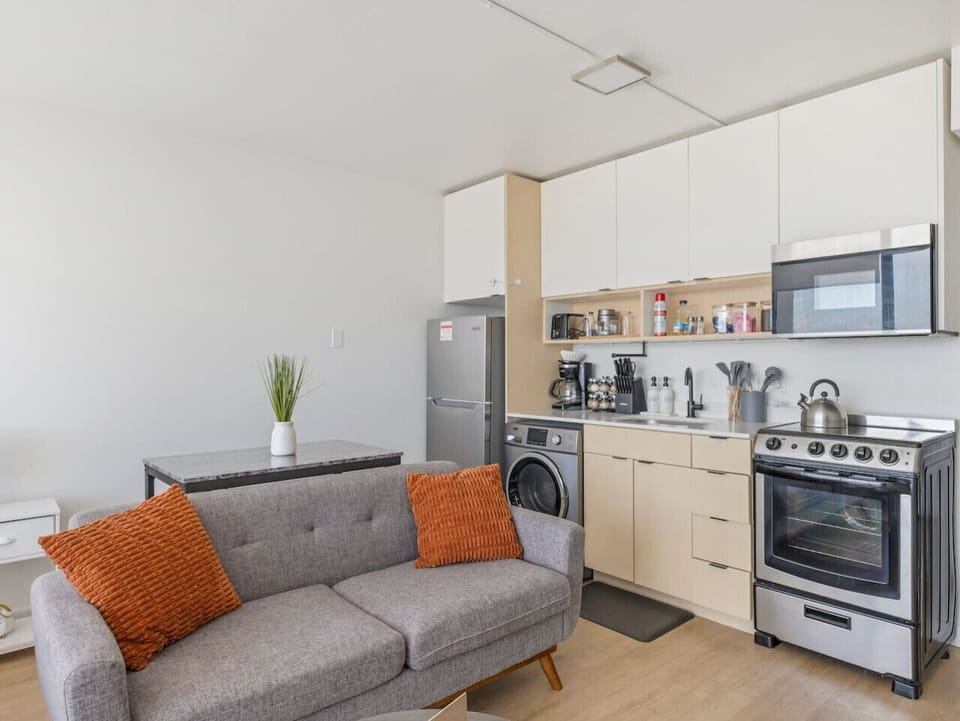 Compact kitchen with stove, microwave, fridge, and washer—perfect for extended stays 🍳🧺