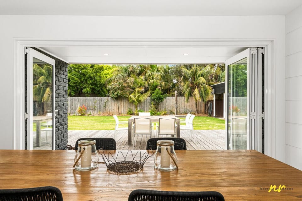 Open dining space leading to alfresco area and garden views