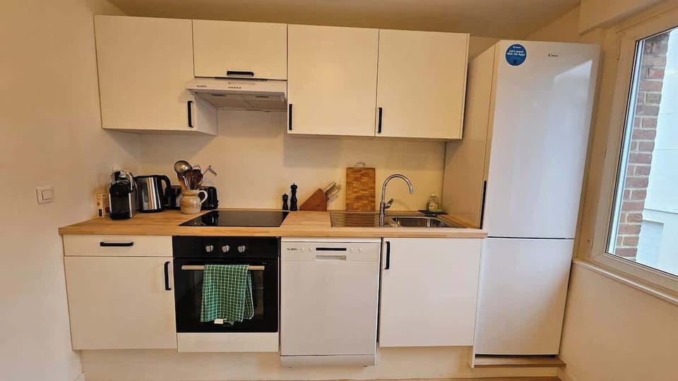 Cuisine équipée avec lave-vaisselle, four, plaques de cuisson, machine à café, bouilloire, grille-pain, micro-ondes et réfrigérateur avec congélateur.
Espace repas pour 5 personnes séparant la cuisine du salon.