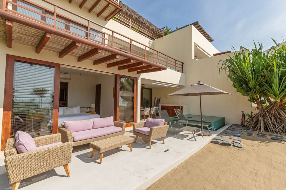 Relax in this spacious outdoor seating area, featuring cozy furniture, shaded pergolas, and direct access to the private plunge pool.