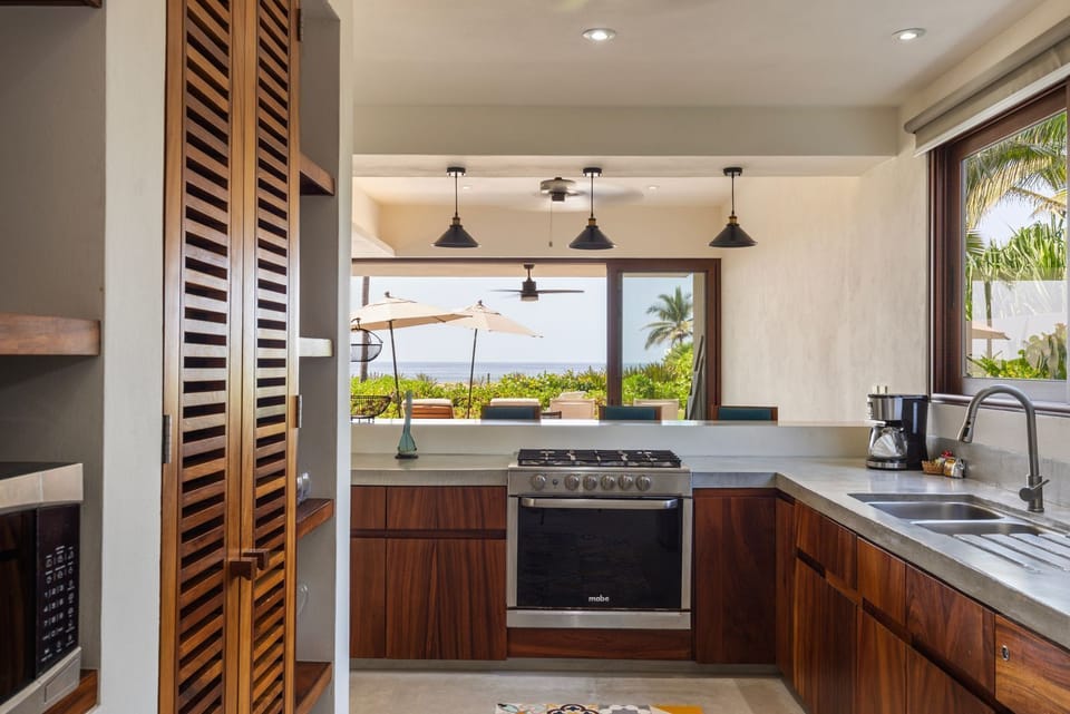 Fully equipped kitchen with sleek wooden cabinetry, bar seating, and an open layout for entertaining.