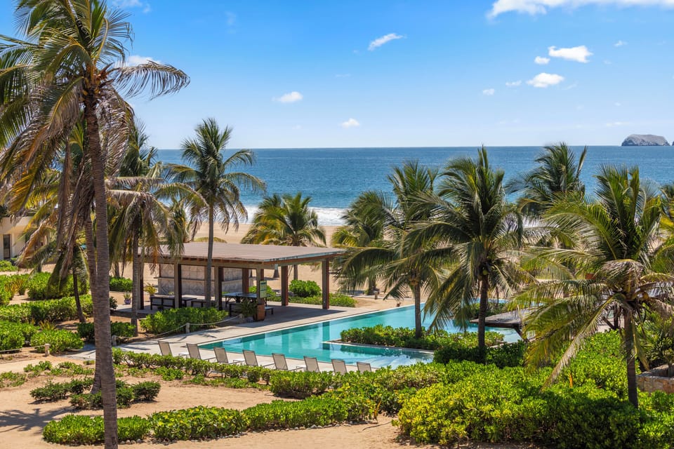 With this stunning beachfront pool surrounded by palm trees in Playa Blanca, Zihuatanejo. Enjoy uninterrupted ocean views, direct beach access, and a luxury beach club experience just steps from your villa.
