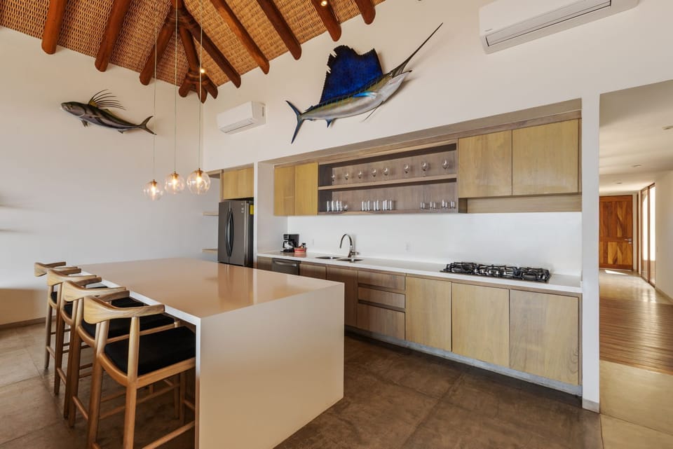 A spacious and elegant kitchen featuring high-end appliances, a large island with bar seating, and beautiful wooden finishes.