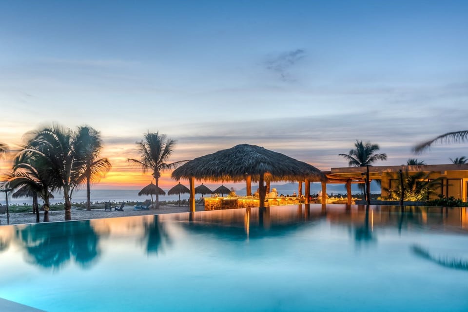 At this beachfront infinity pool and palapa lounge in Zihuatanejo. Ideal for evening drinks, romantic dinners, and luxury coastal living in Playa Blanca.
