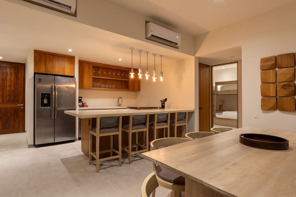 Cook and entertain in this sleek kitchen, featuring high-end appliances, elegant wood cabinetry, and a spacious breakfast bar with stylish pendant lighting.