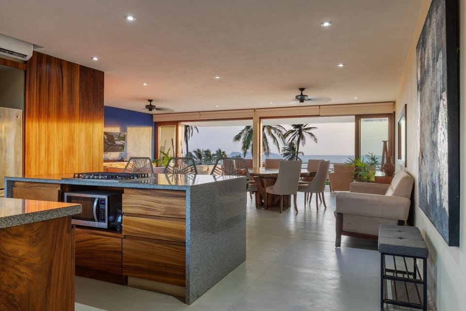 A fully equipped kitchen with modern appliances, rich wooden finishes, and bar seating, offering a luxurious cooking and dining experience.