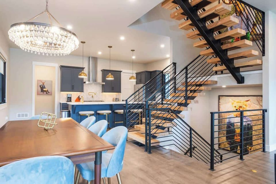 - Chic dining space set beside a striking open staircase with modern railing
- Kitchen features pendant lighting stainless steel appliances and extra counter space
- Perfect for hosting meals or enjoying morning coffee with a view