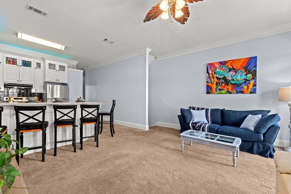 A bright living room open to the kitchen, featuring a stylish breakfast bar for easy dining and casual gatherings.