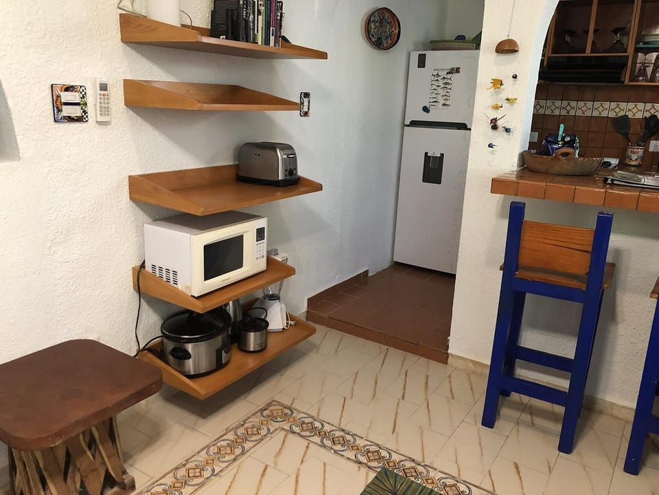 Cozy kitchen nook with rustic wooden shelves and breakfast bar